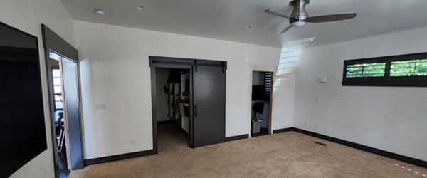 A room with a ceiling fan and black walls.