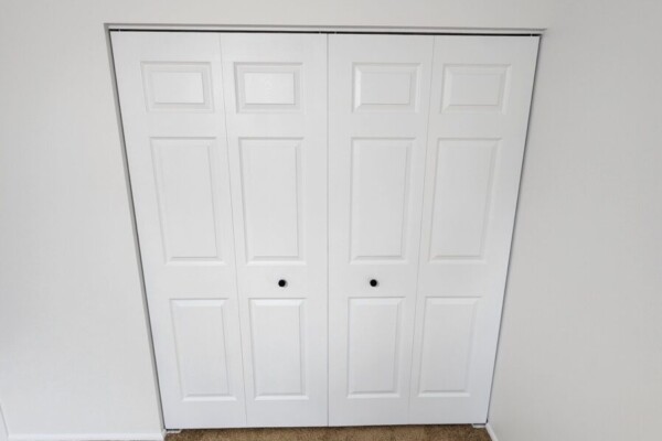 Freshly painted white doors with black door knobs